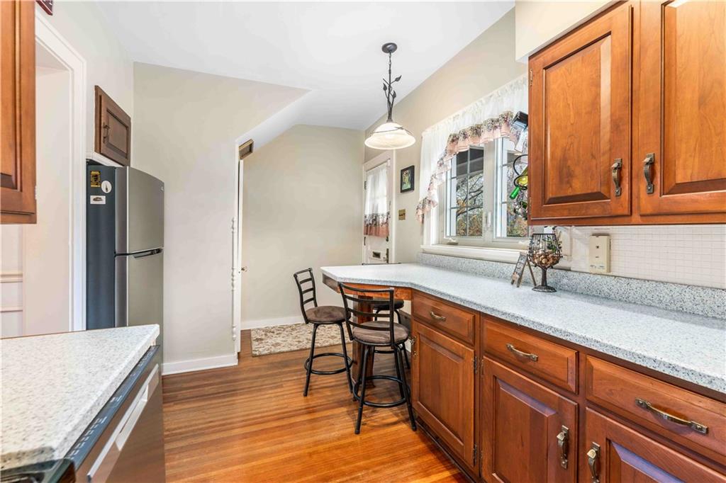 201 4th Street Beaver, PA 15009 - Photo 16 of 42 a kitchen with stainless steel appliances granite countertop a refrigerator a sink dishwasher a dining table and chairs with wooden floor