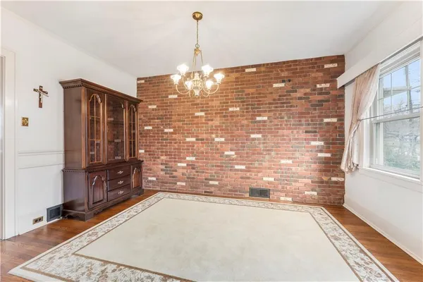 a kitchen with stainless steel appliances granite countertop a refrigerator a stove a sink dishwasher a dining table and chairs with wooden floor
