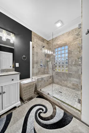 a bathroom with a granite countertop sink a mirror and a shower