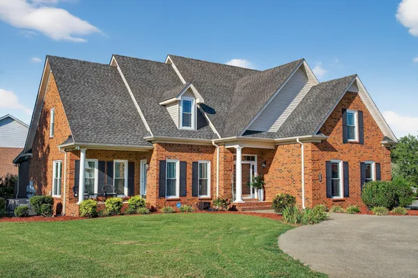 front view of a brick house with a yard