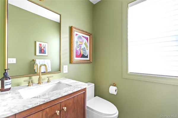 a bathroom with a granite countertop toilet sink and mirror