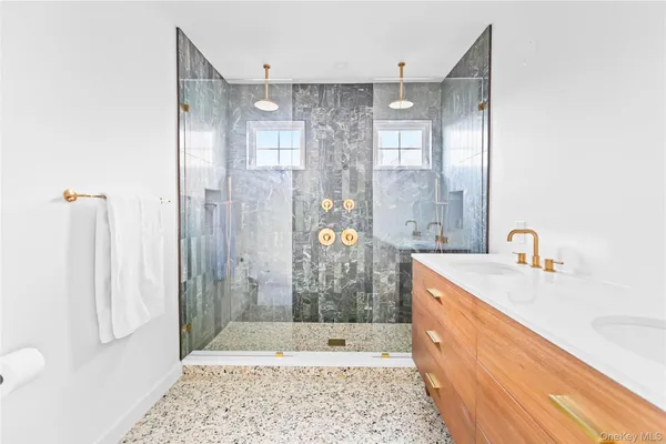 a bathroom with a granite countertop shower a sink and a mirror