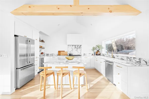 a kitchen with stainless steel appliances kitchen island granite countertop a refrigerator and a stove top oven