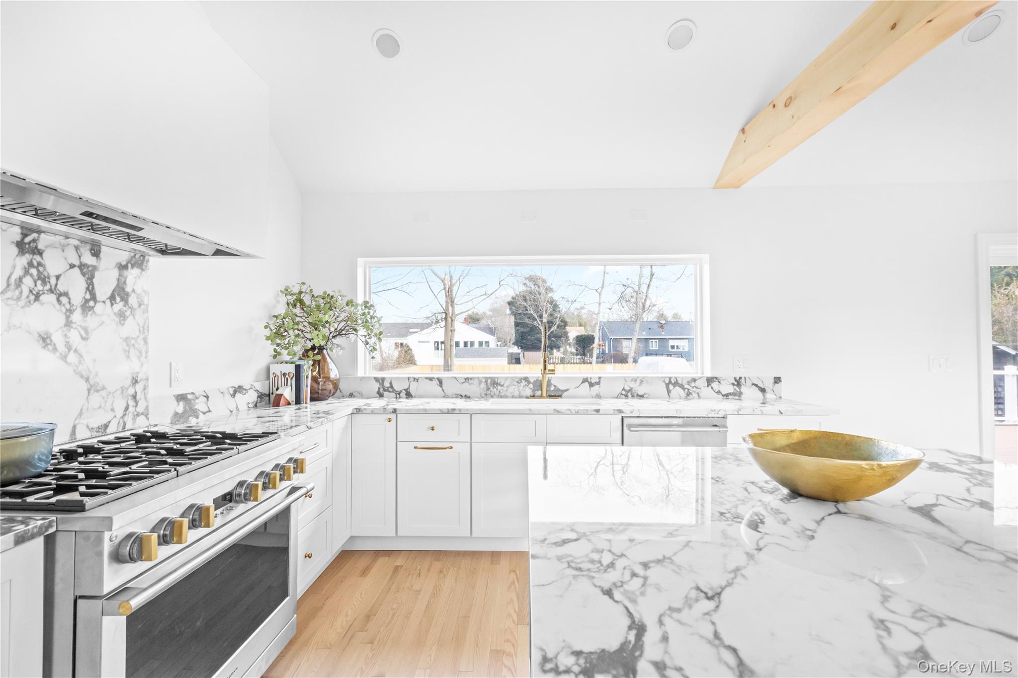 21 North Howells Point Road Bellport, NY 11713 - Photo 7 of 21 a kitchen with a stove a sink and a wooden cabinets
