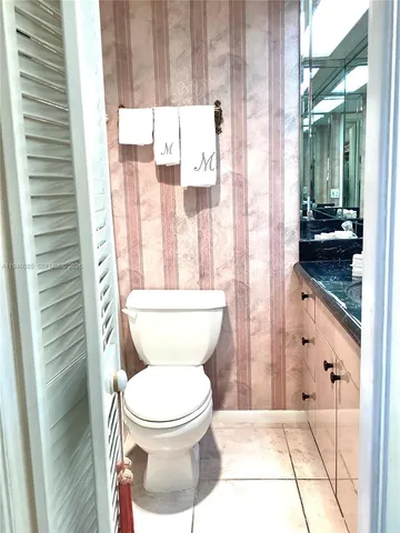 a bathroom with a granite countertop sink a mirror and a toilet