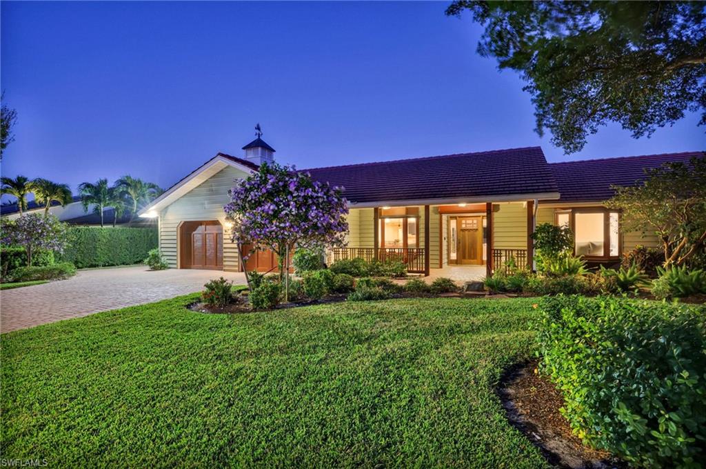 4870 Whispering Pine Way Naples, FL 34103 - Photo 1 of 43 a front view of a house with a yard