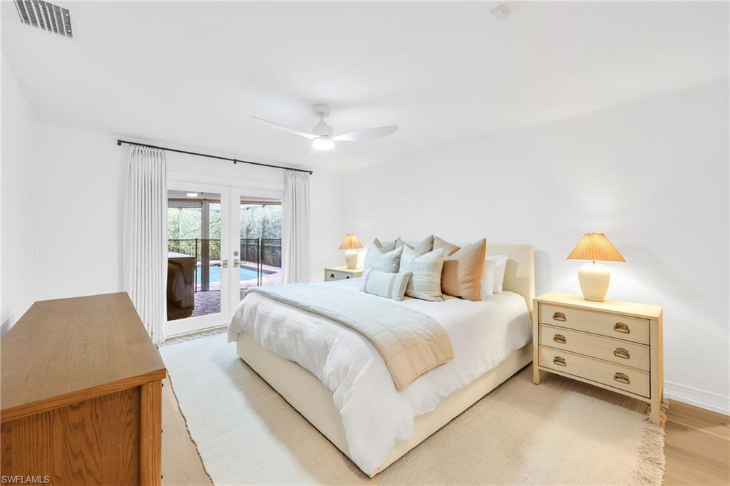 4870 Whispering Pine Way Naples, FL 34103 - Photo 16 of 43 a bedroom with a bed and a cabinets