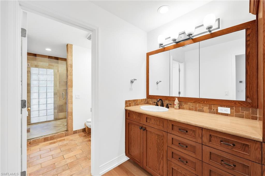 4870 Whispering Pine Way Naples, FL 34103 - Photo 17 of 43 a bathroom with a sink and a mirror