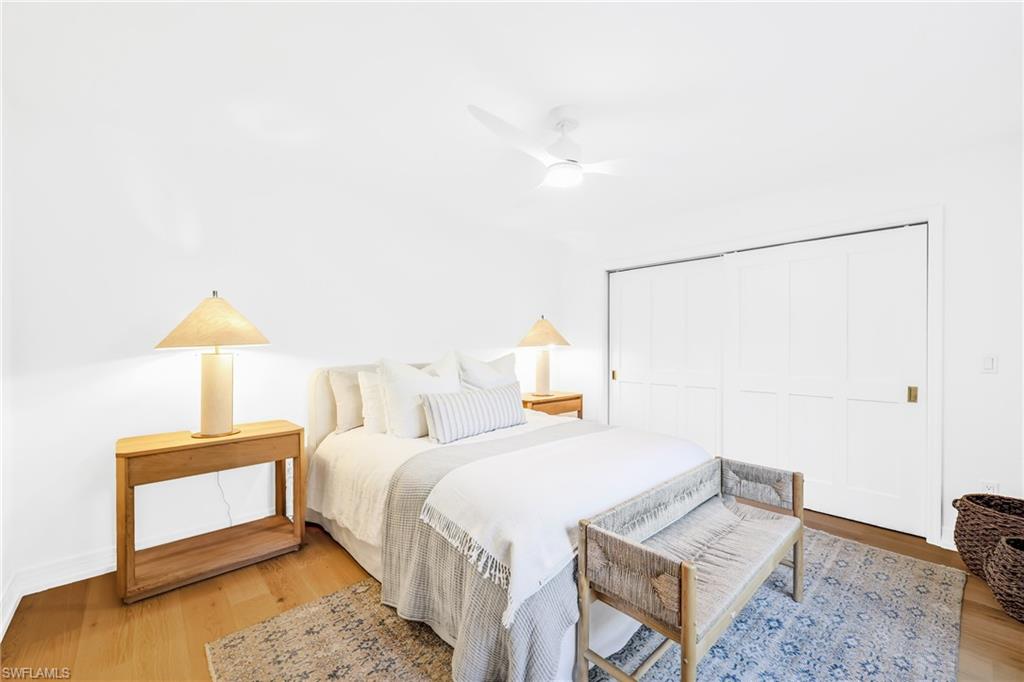 4870 Whispering Pine Way Naples, FL 34103 - Photo 24 of 43 a bedroom with a bed and a lamp on table