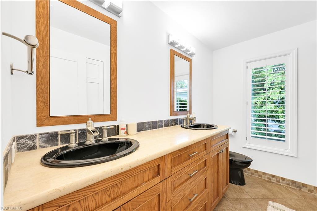 4870 Whispering Pine Way Naples, FL 34103 - Photo 29 of 43 a bathroom with a sink and a window