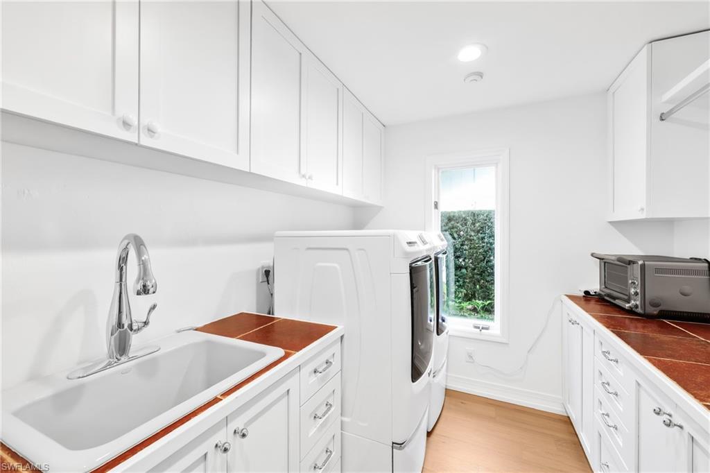 4870 Whispering Pine Way Naples, FL 34103 - Photo 31 of 43 a kitchen with a sink stove and cabinets