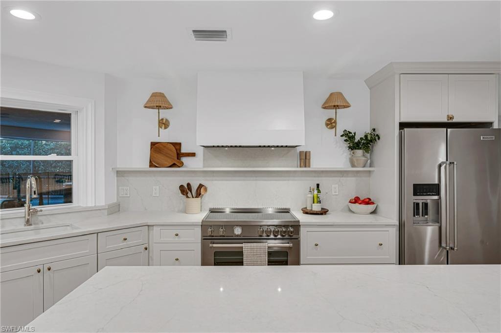 4870 Whispering Pine Way Naples, FL 34103 - Photo 5 of 43 a kitchen with stainless steel appliances a refrigerator and a sink