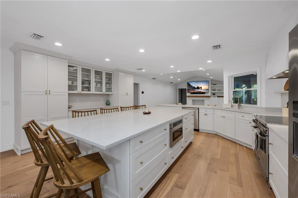 4870 Whispering Pine Way Naples, FL 34103 - Photo 7 of 43 a large kitchen with a table and chairs in it