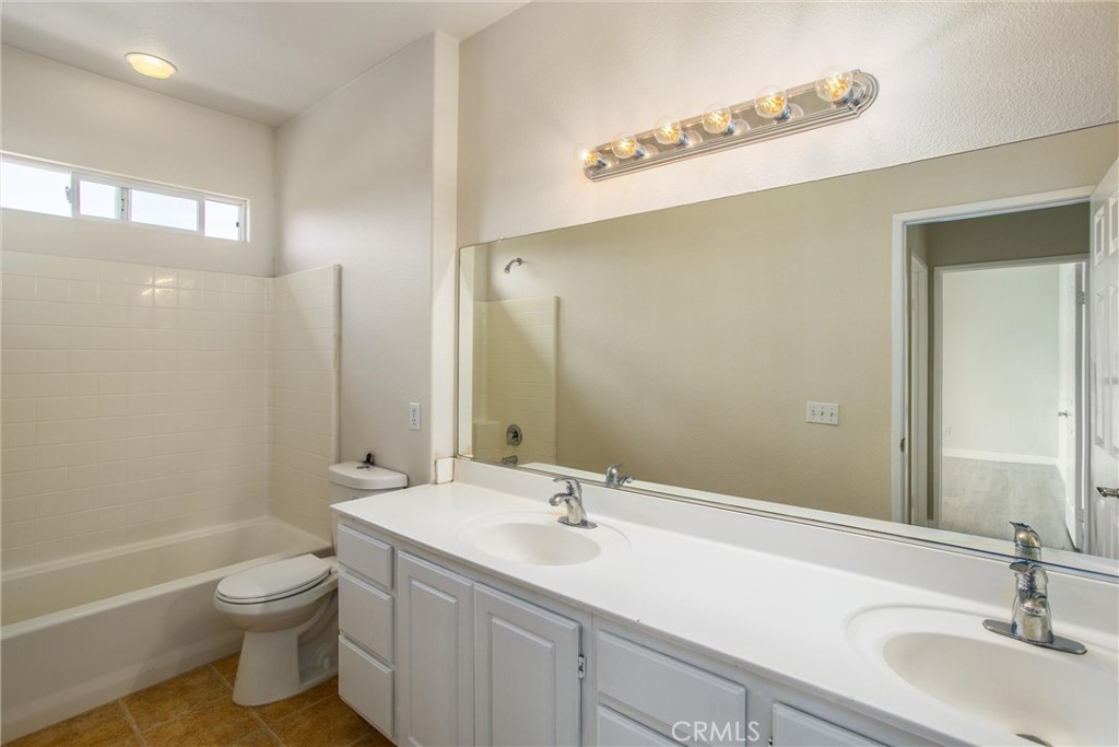 19429 Norwich Drive Riverside, CA 92508 - Photo 31 of 45 a bathroom with a granite countertop sink a toilet and a tub