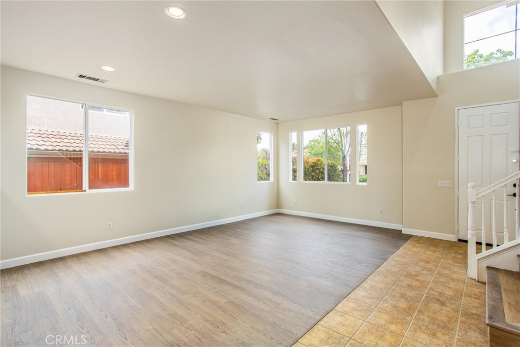19429 Norwich Drive Riverside, CA 92508 - Photo 8 of 45 an empty room with wooden floor and windows