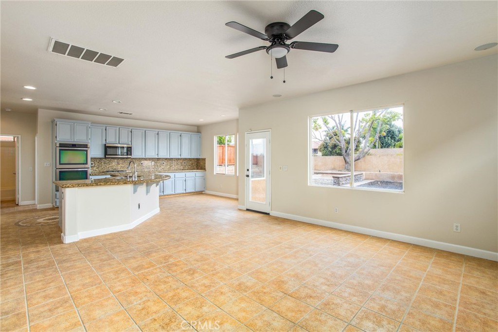 19429 Norwich Drive Riverside, CA 92508 - Photo 10 of 45 a view of a kitchen with a stove cabinets a ceiling fan and wooden floor