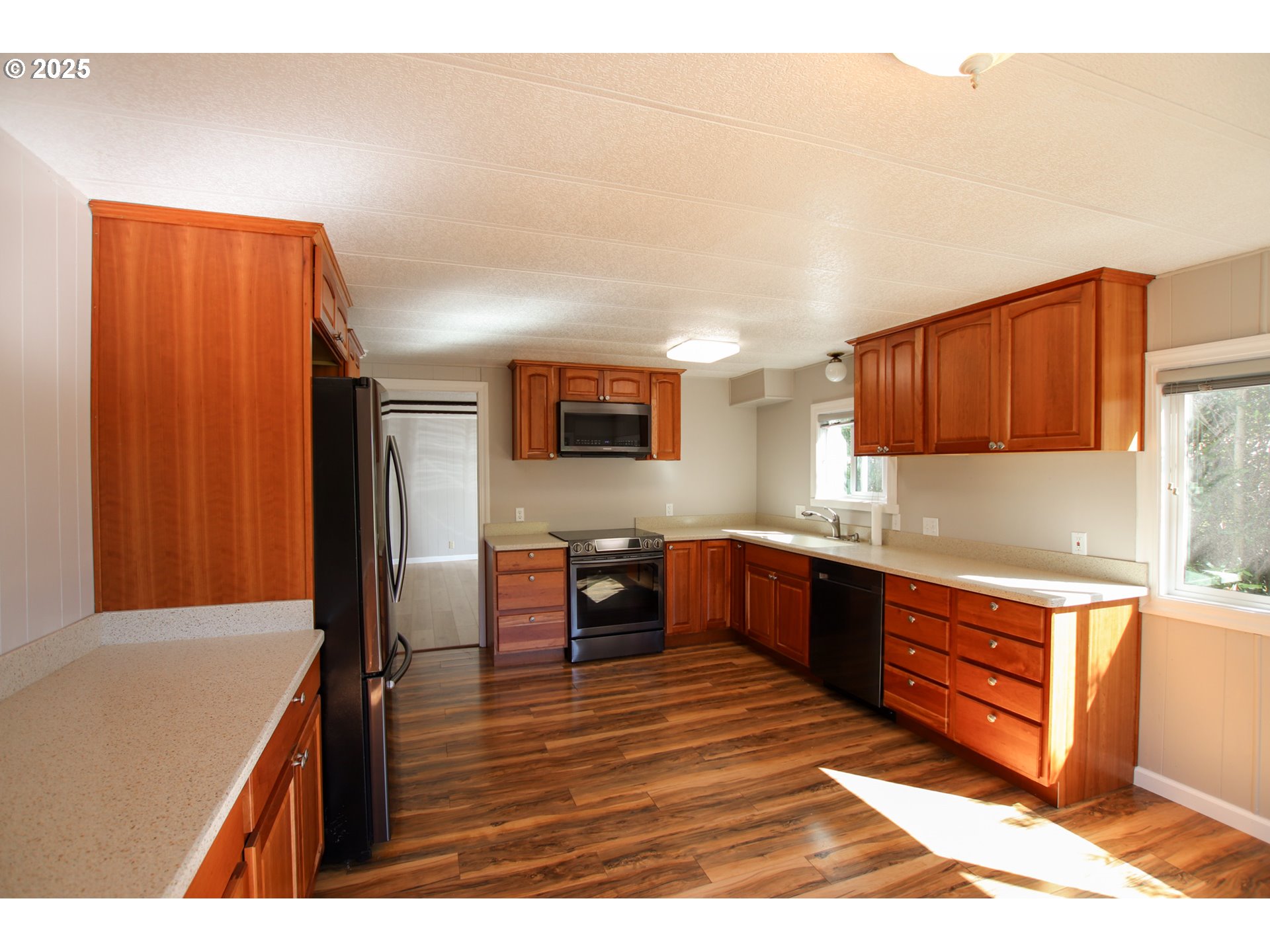 1600 Rhododendron Drive, Unit 279 Florence, OR 97439 - Photo 12 of 30 a kitchen with stainless steel appliances granite countertop a refrigerator and wooden cabinets