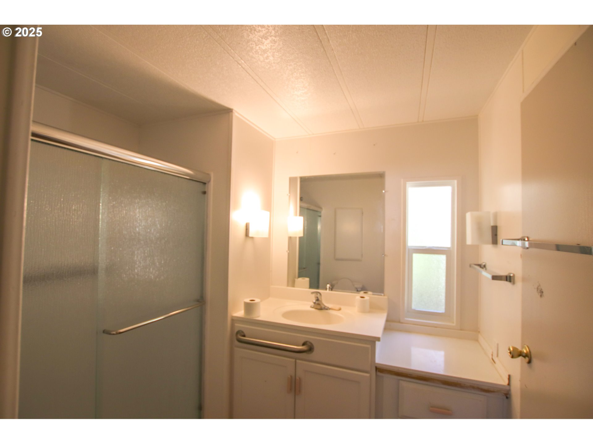 1600 Rhododendron Drive, Unit 279 Florence, OR 97439 - Photo 21 of 30 a bathroom with a sink mirror and a shower