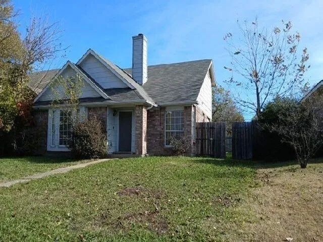 a view of a house with backyard and a tree
