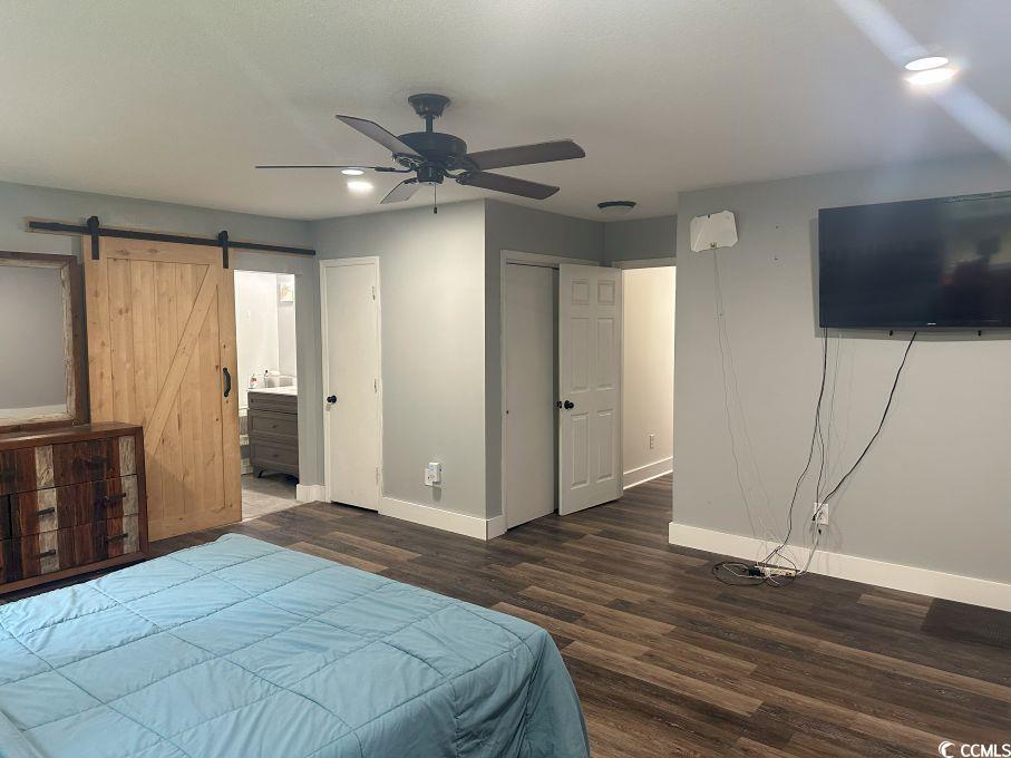 214 Rum Bluff Boulevard Longs, SC 29568 - Photo 23 of 36 Bedroom with a barn door, wood finished floors, en