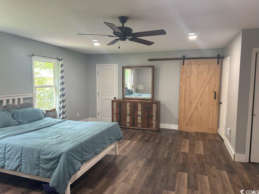 214 Rum Bluff Boulevard Longs, SC 29568 - Photo 24 of 36 Bedroom featuring a barn door, dark wood finished