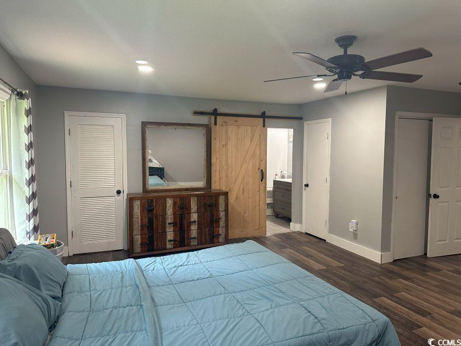 214 Rum Bluff Boulevard Longs, SC 29568 - Photo 25 of 36 Bedroom featuring a barn door, wood finished floor