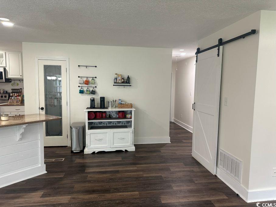 214 Rum Bluff Boulevard Longs, SC 29568 - Photo 3 of 36 Kitchen featuring a barn door, dark wood-style flo
