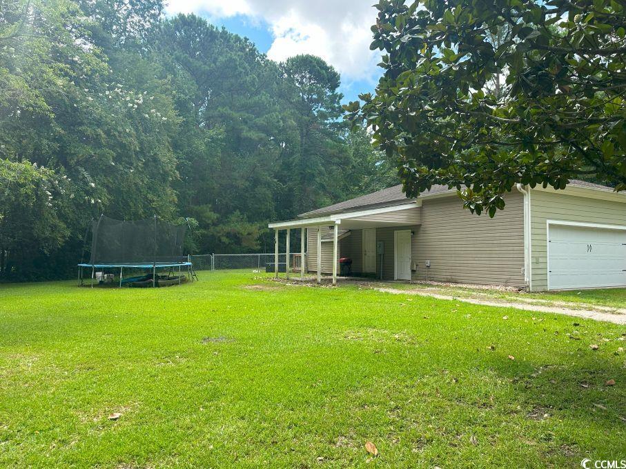 214 Rum Bluff Boulevard Longs, SC 29568 - Photo 31 of 36 View of yard with a trampoline