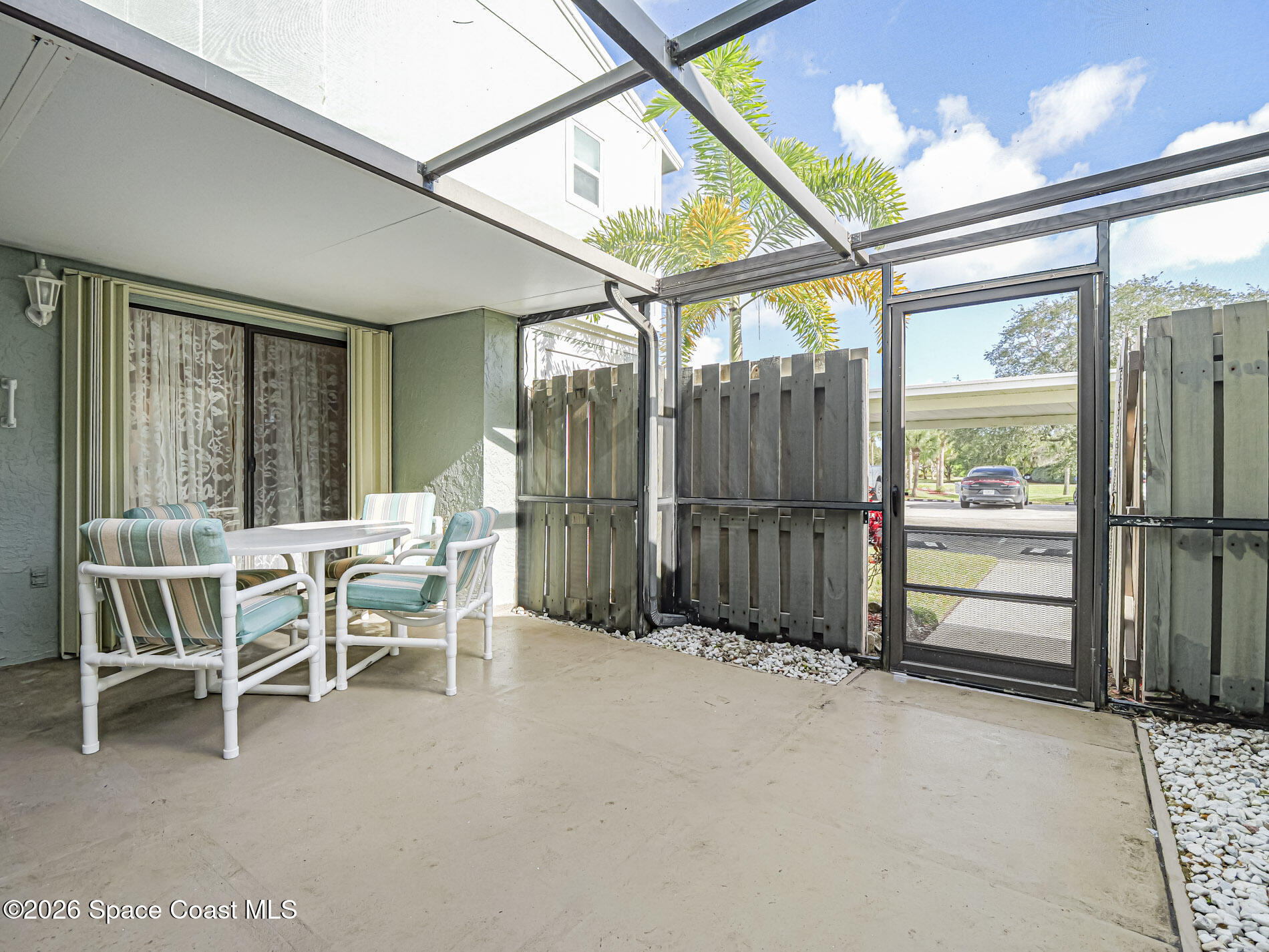 1198 Breezy Way, Unit 7 Sebastian, FL 32958 - Photo 4 of 34 a view of a porch with chairs and floor to ceiling window