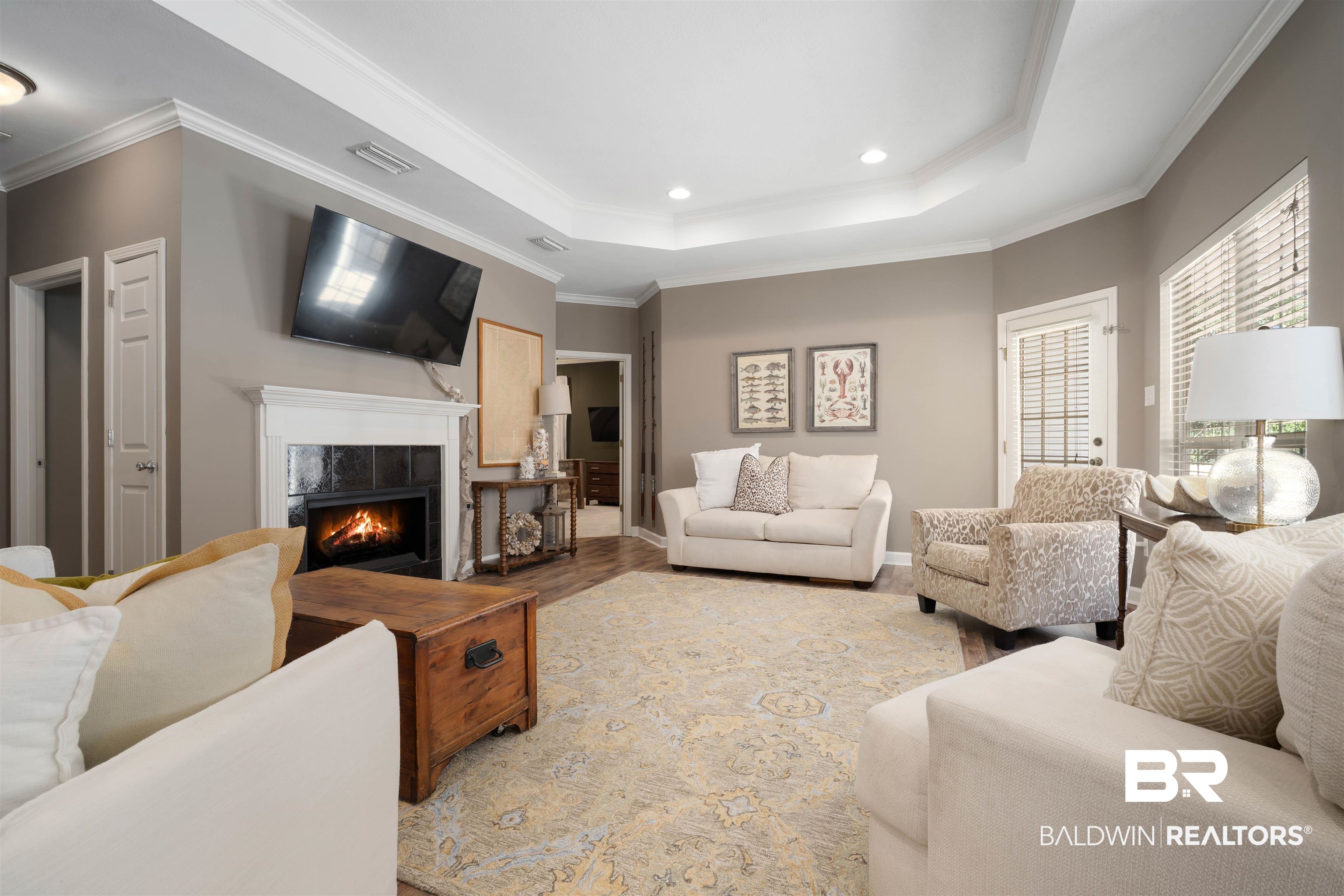 27288 Parker Lane Daphne, AL 36526 - Photo 4 of 29 Living room with a tiled fireplace, crown molding, a tray ceiling, wood finished floors, and recessed lighting