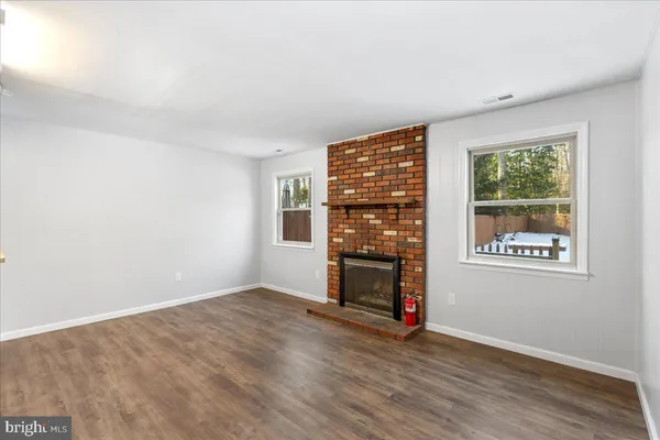 an empty room with wooden floor and window