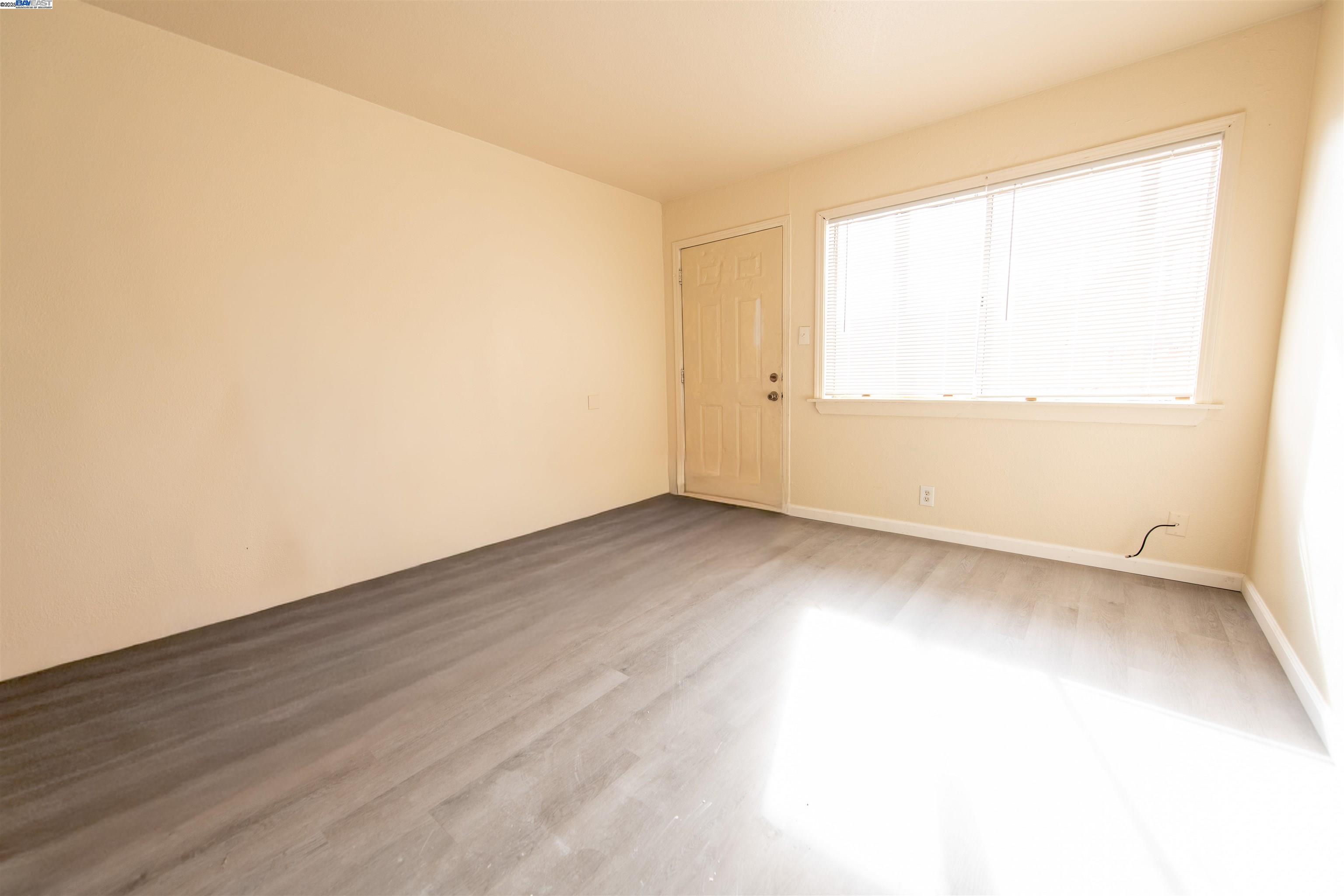 731 Calvados Avenue, Unit B Sacramento, CA 95815 - Photo 7 of 7 an empty room with wooden floor and windows