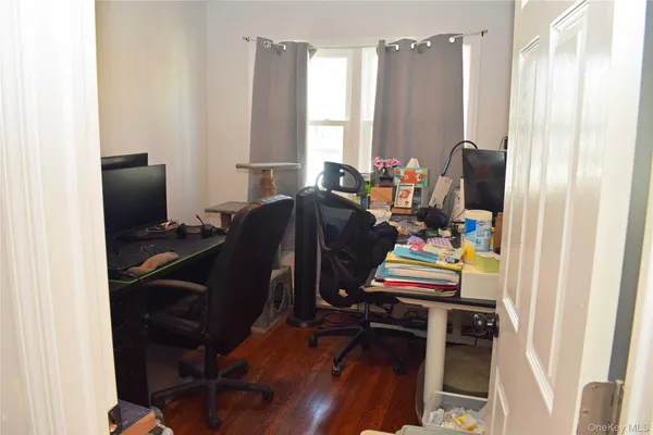 a view of a workspace with furniture and a window