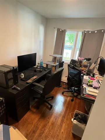 a view of a workspace with furniture and a window