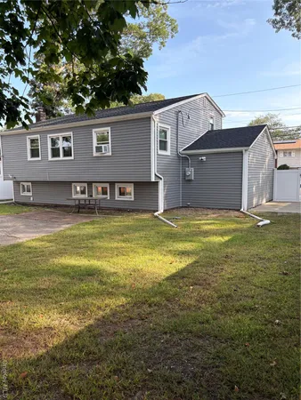 a view of a house with a big yard and large trees