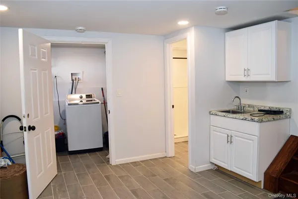 a view of a kitchen with white cabinets and wooden floor