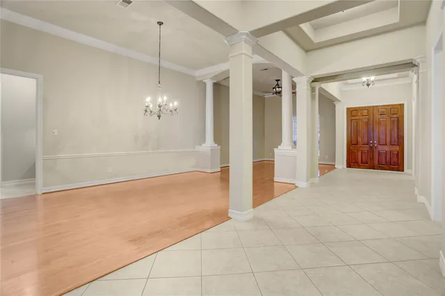a view of a livingroom with a chandelier fan and kitchen view