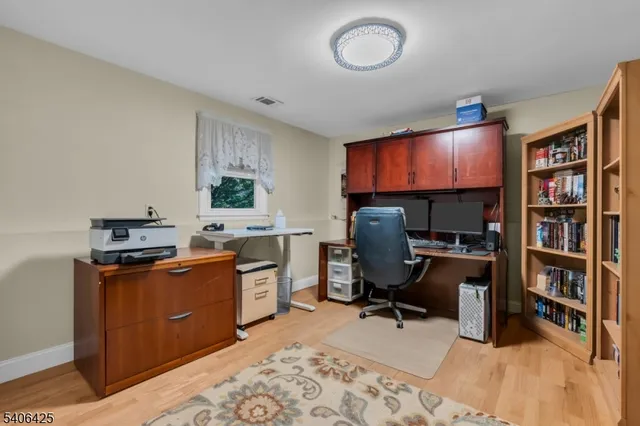 a view of a workspace with furniture and a window