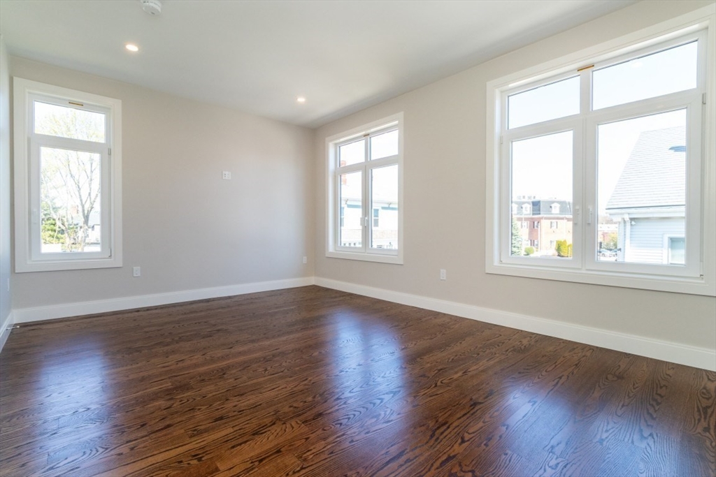 15 Tanglewood Road, Unit A Boston, MA 02126 - Photo 17 of 28 a view of an empty room with wooden floor and a window