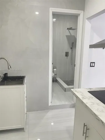 a bathroom with a granite countertop sink a toilet and shower