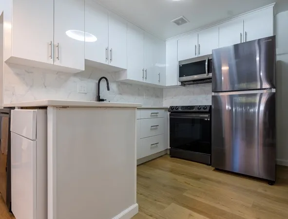 a kitchen with stainless steel appliances granite countertop a refrigerator and a sink