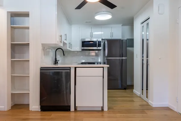 a kitchen with stainless steel appliances granite countertop a refrigerator and a stove top oven