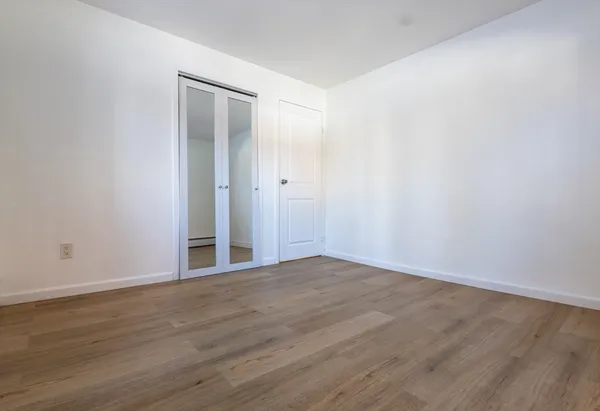 a view of an empty room with wooden floor