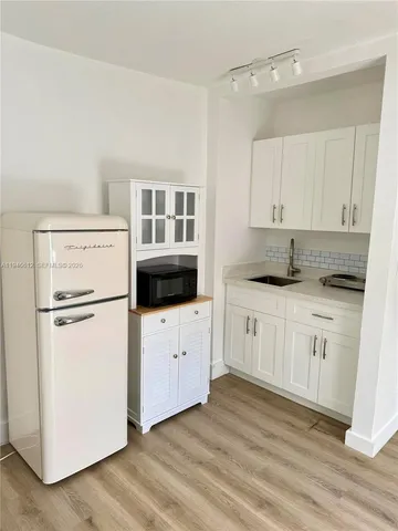 a kitchen with white cabinets and white appliances