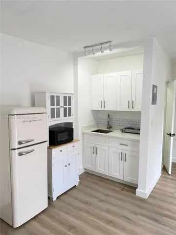 a kitchen with white cabinets and white appliances