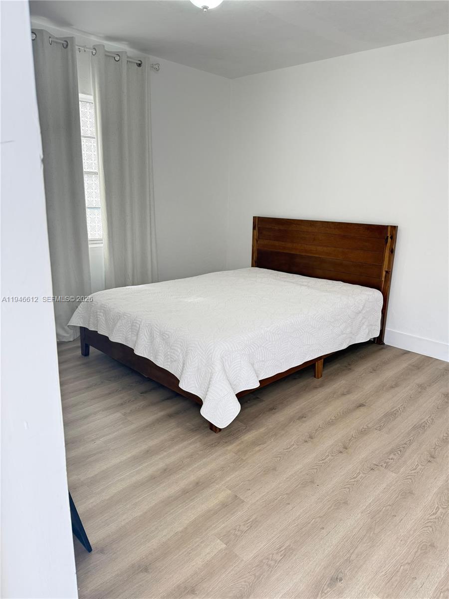 541 East 38th Street, Unit E Hialeah, FL 33013 - Photo 5 of 11 a bed sitting in a bedroom next to a window