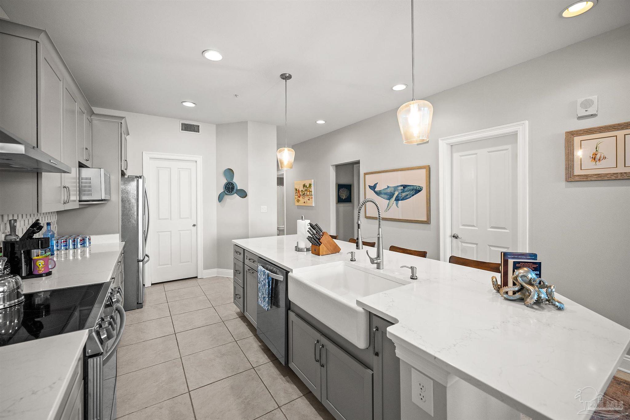 28250 Canal Road, Unit 205 Orange Beach, AL 36561 - Photo 13 of 60 a kitchen that has a lot of cabinets and wooden floor