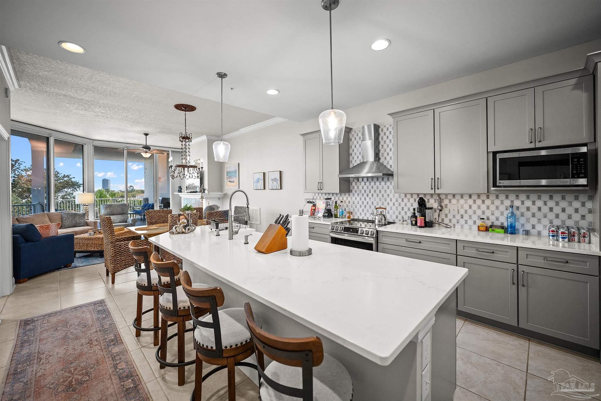 28250 Canal Road, Unit 205 Orange Beach, AL 36561 - Photo 15 of 60 a kitchen with stainless steel appliances kitchen island granite countertop a table chairs sink and cabinets