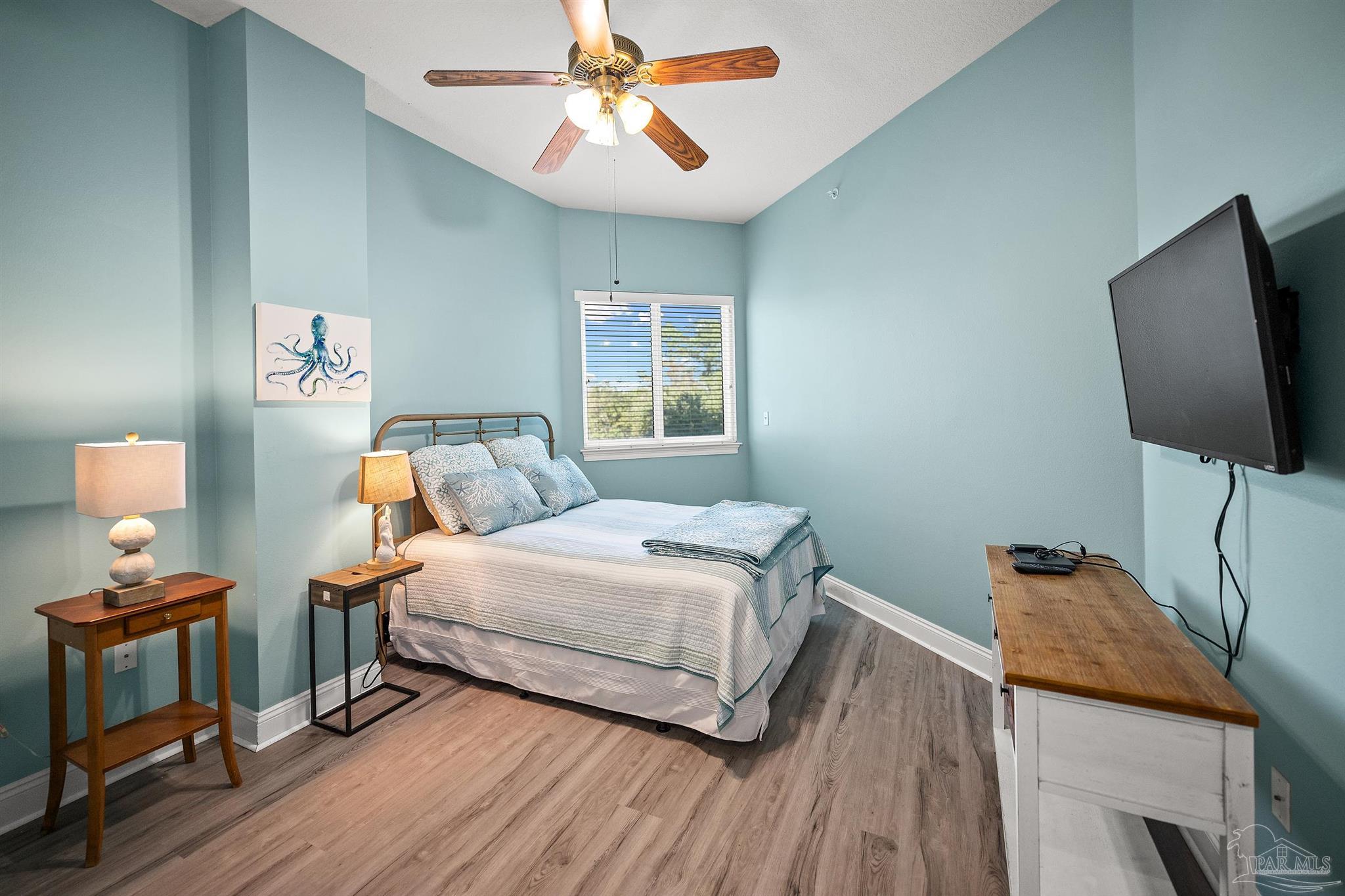 28250 Canal Road, Unit 205 Orange Beach, AL 36561 - Photo 22 of 60 a bedroom with a bed and wooden floor
