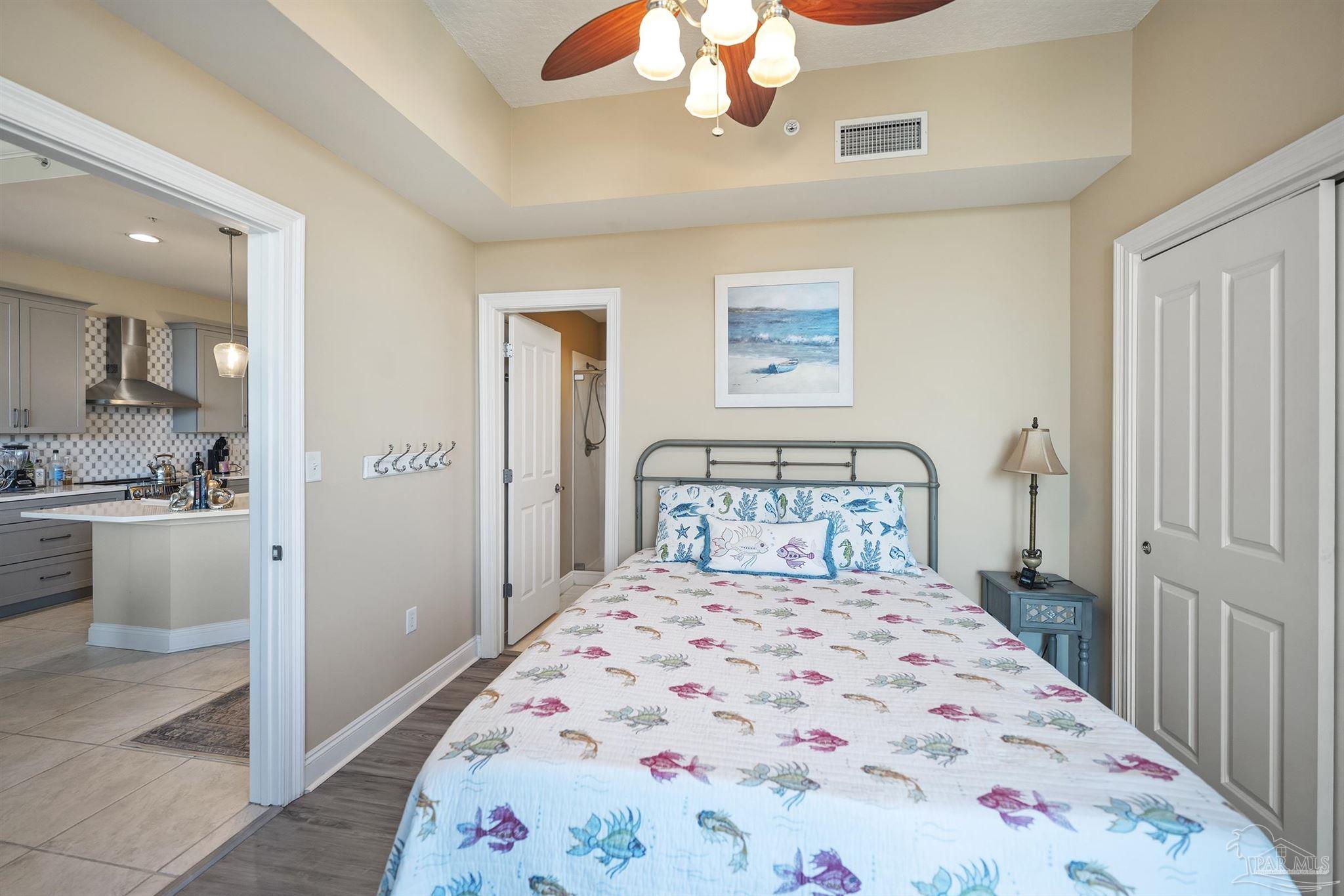 28250 Canal Road, Unit 205 Orange Beach, AL 36561 - Photo 24 of 60 a bedroom with a bed and a chandelier